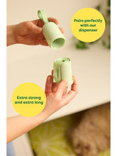 These compostable poop bags are extra strong and extra long and pair perfectly with our dispenser. A pair of hands opens up the dispenser revealing a roll of compostable poop bags nestled inside