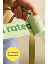 A poop bag is being pulled out of the roll. Callout reads: TUV OKCompost Industrial and Home Certified